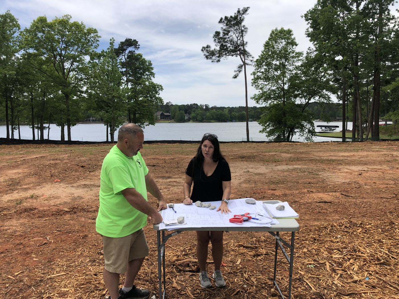 Reviewing building plans on site at the lake lot